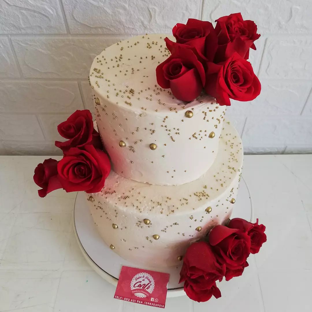 Pastel blanco de dos niveles con rosas rojas