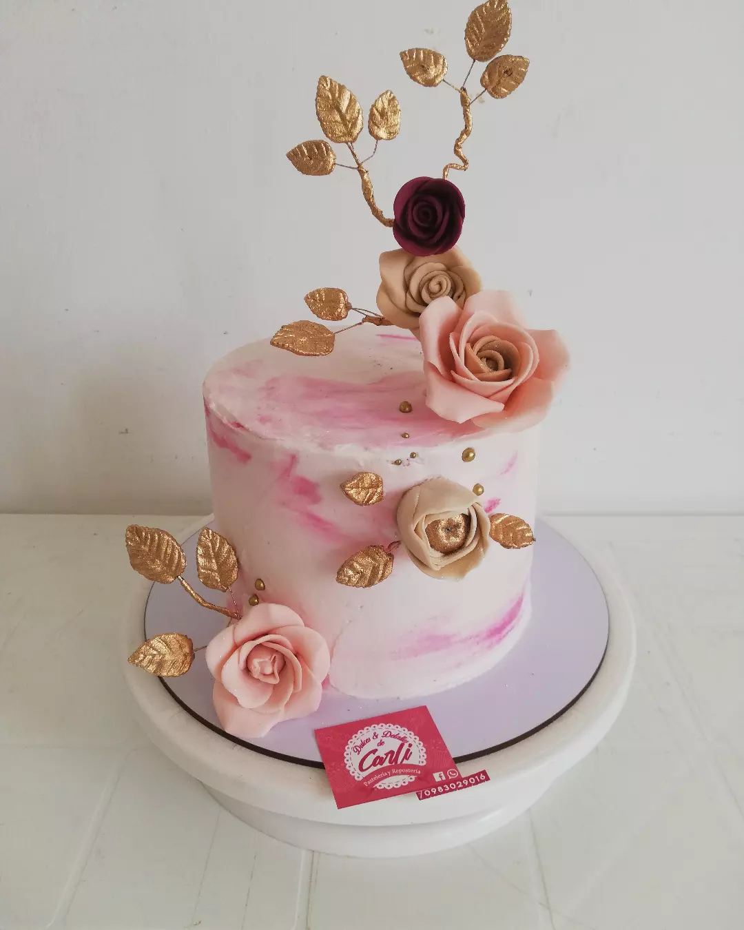 Pastel rosa y blanco con flores y hojas doradas