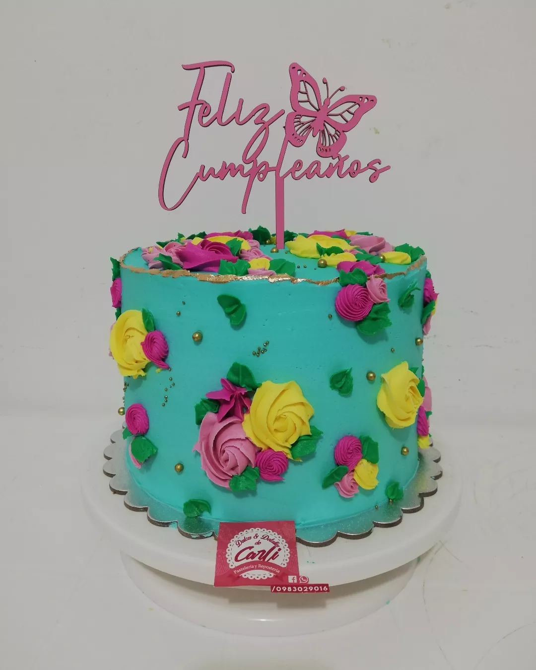 Pastel turquesa con flores y topper de cumpleaños