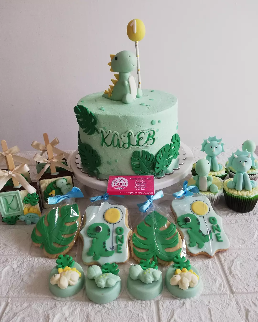 Pastel verde de dinosaurio con galletas decoradas