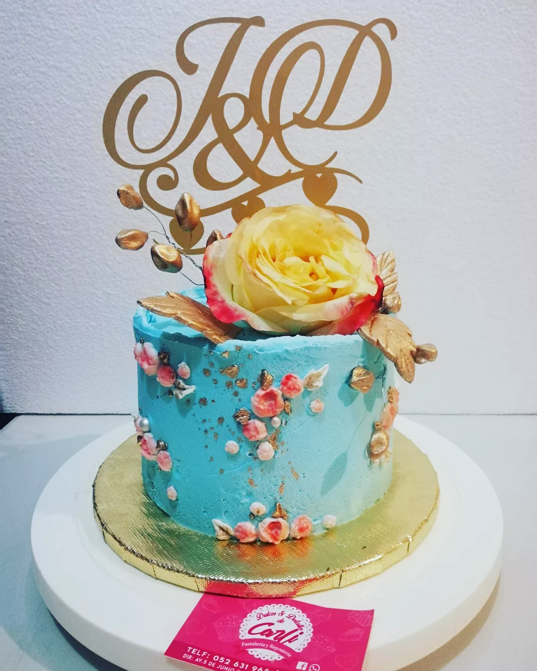 Pastel turquesa floral con monograma dorado