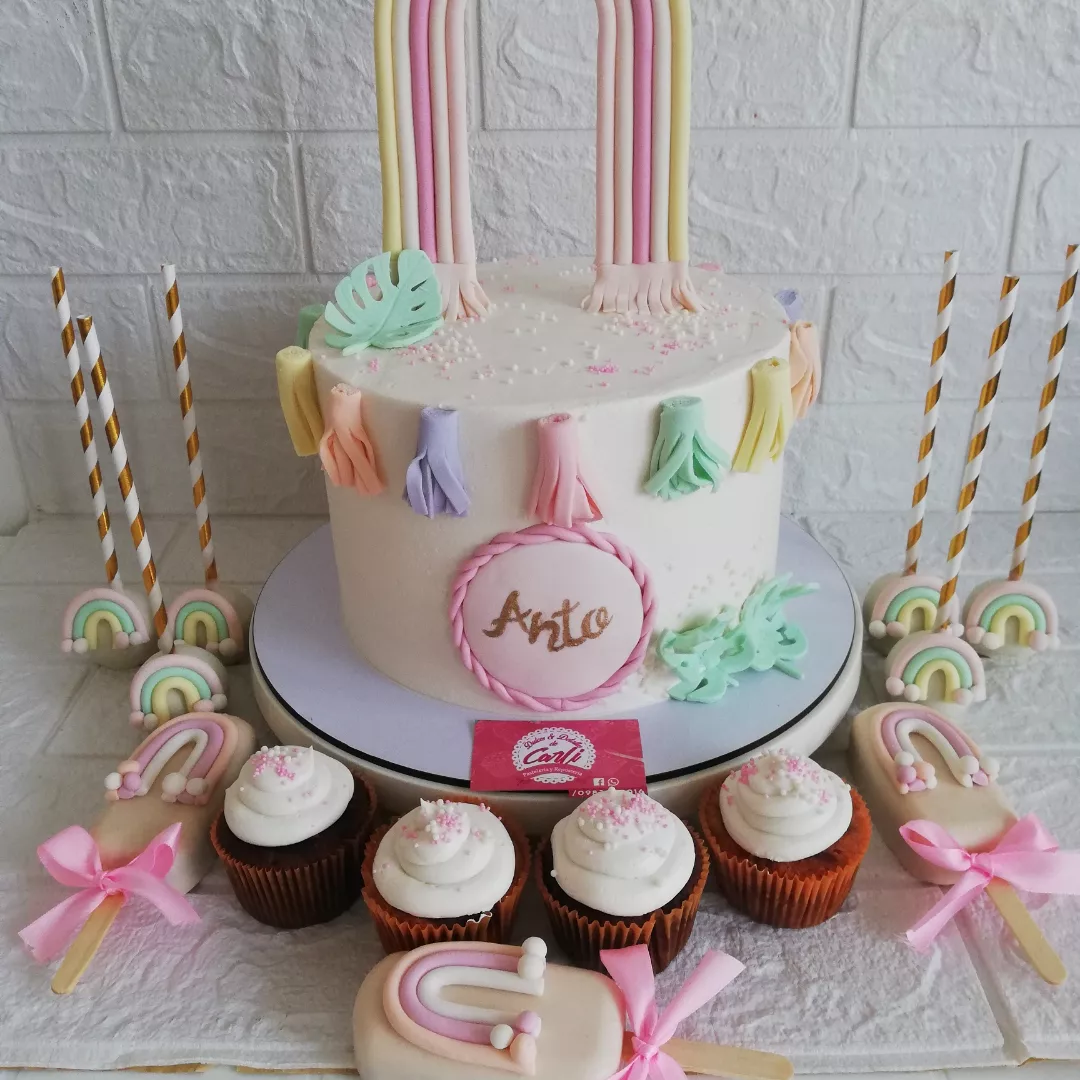 Pastel pastel con cupcakes, cake pops y dulces a juego
