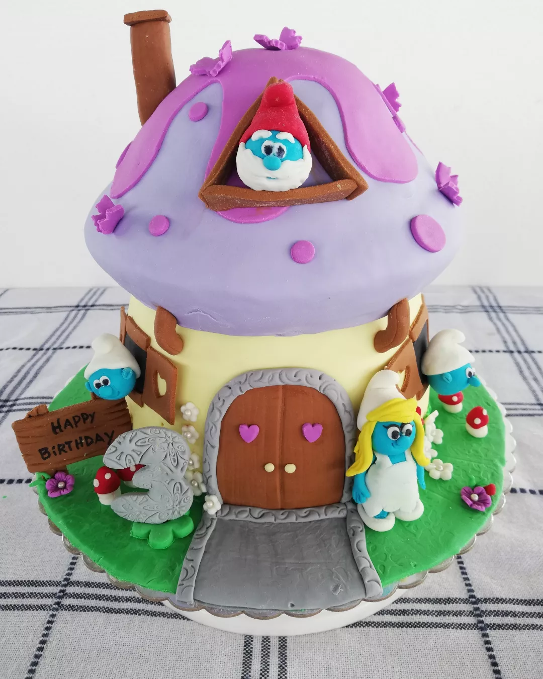 Pastel en forma de casa de hongo con personajes azules