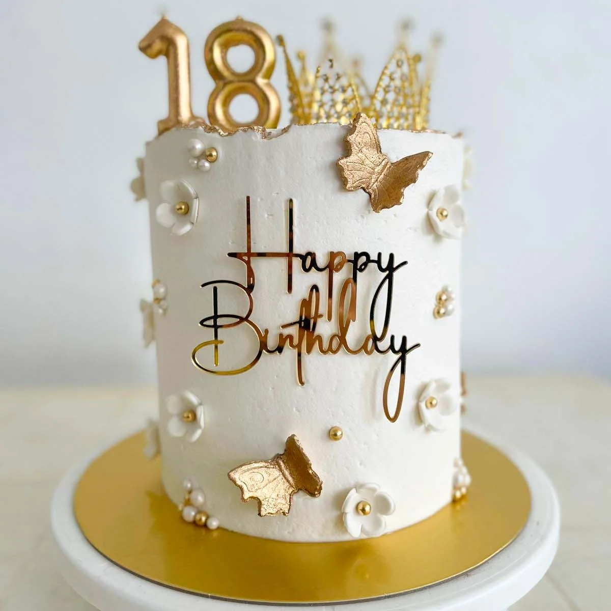Pastel blanco de dieciocho años con mariposas y corona doradas