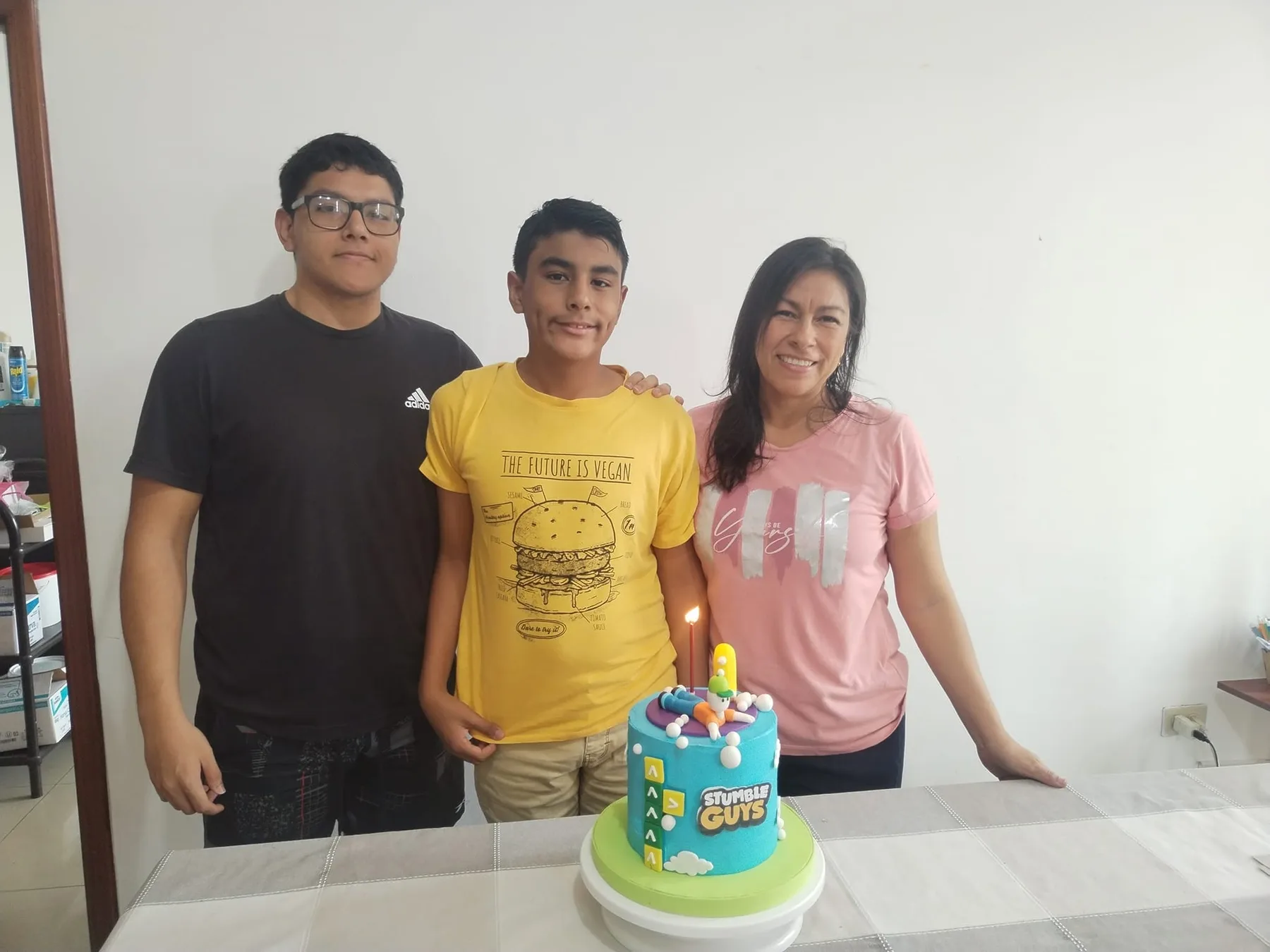 Carlina junto a sus dos hijos y un pastel de cumpleaños